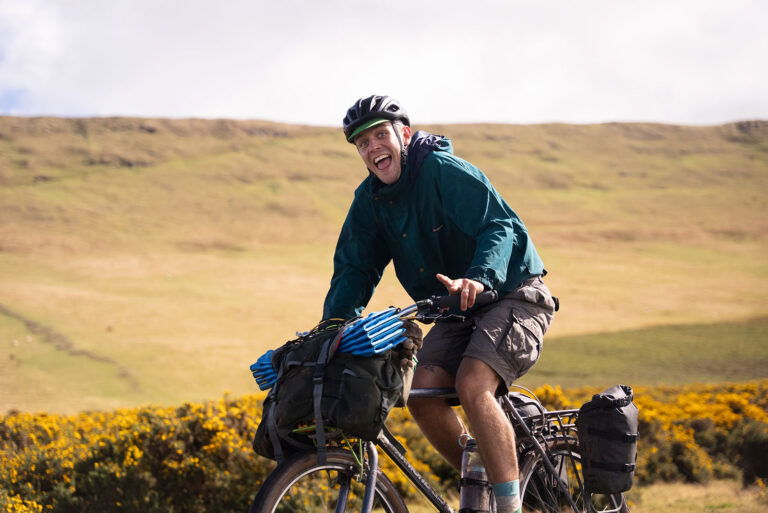 Man on a bike looking down the camera happy. Whilst riding Tailfin Detours event.