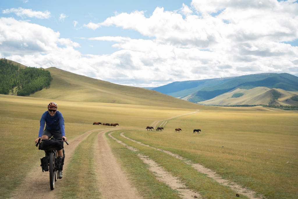 A cyclist on a scenic gravel road adventure using Tailfin bikepacking gear.