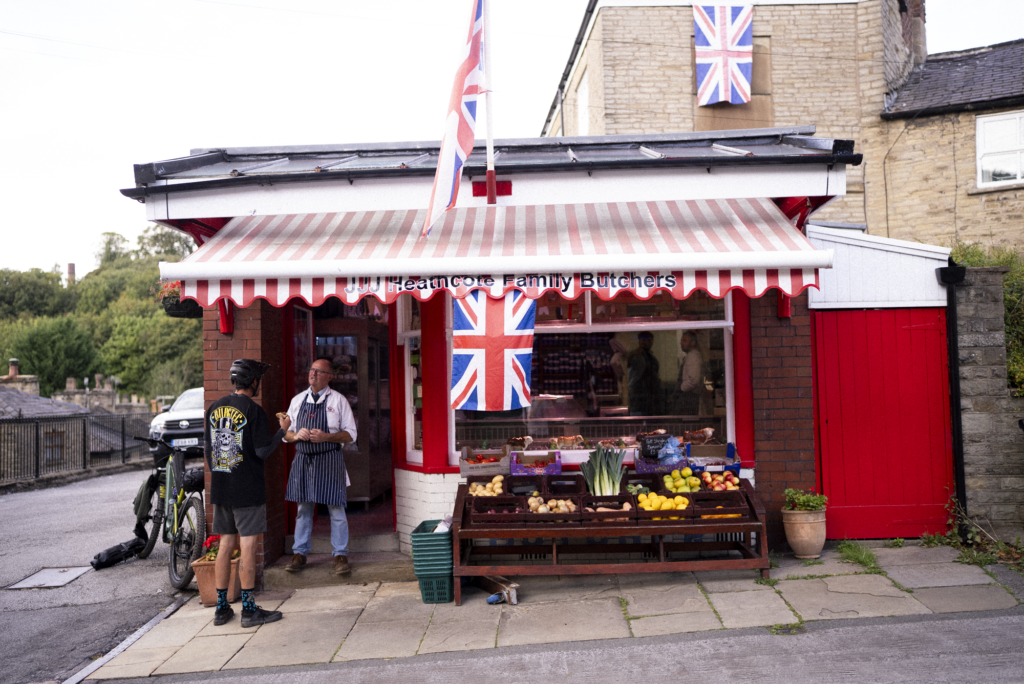 A mountain bike with a Tailfin bag outside a traditional British village butcher.